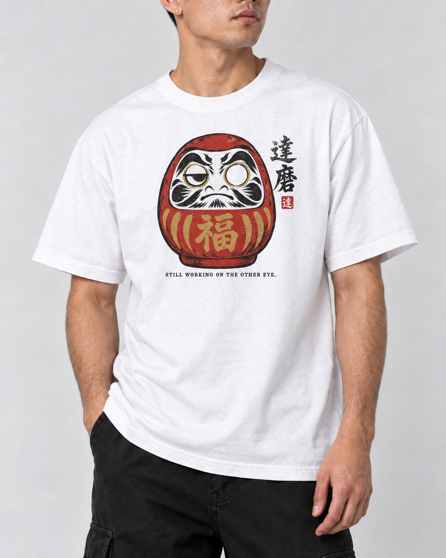 Still Working on the Other Eye Daruma T-Shirt in White, close-up