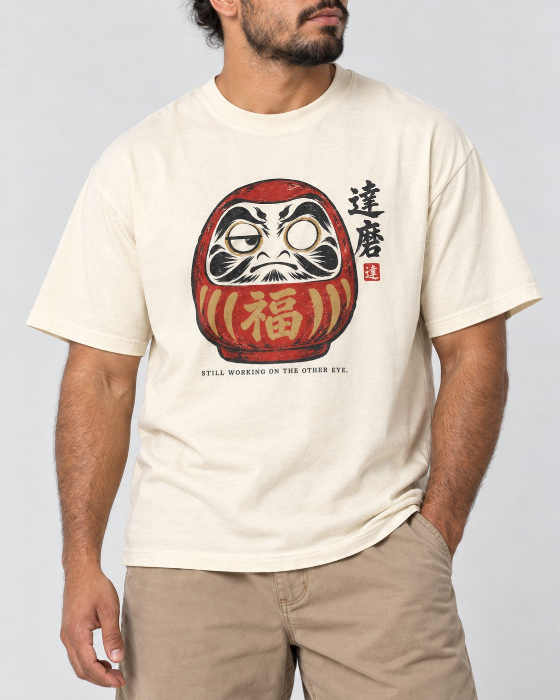 Still Working on the Other Eye Daruma T-Shirt in Ivory, close-up
